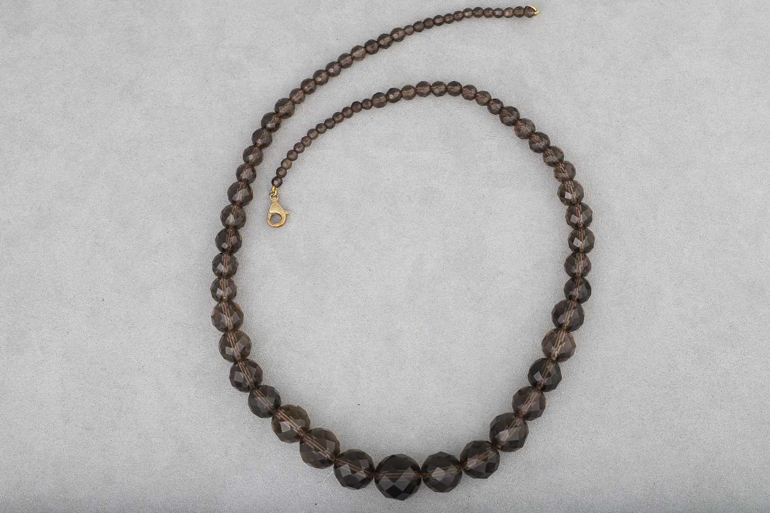 Lot 23 - A GRADUATED SMOKY QUARTZ NECKLACE, faceted...