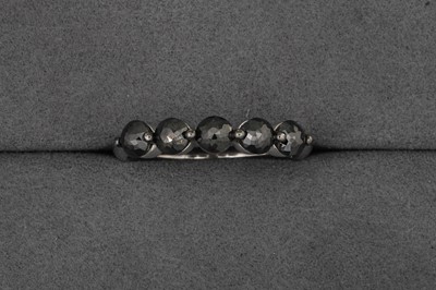 A BLACK DIAMOND FIVE STONE RING, mounted in...