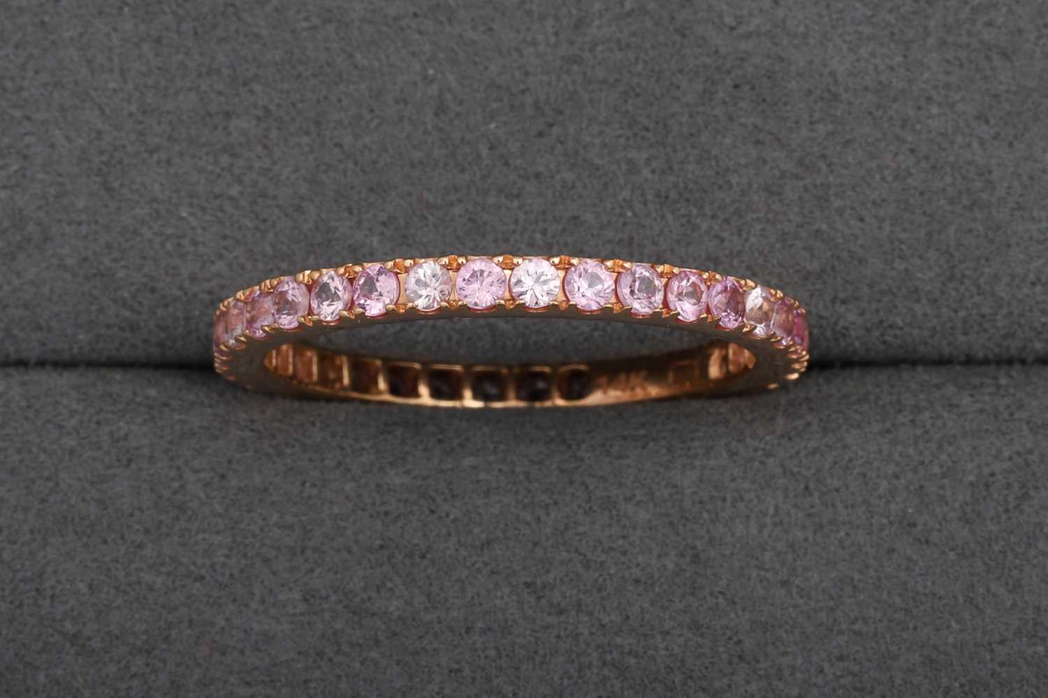 Lot 83 - A PINK SAPPHIRE FULL ETERNITY RING, mounted in...