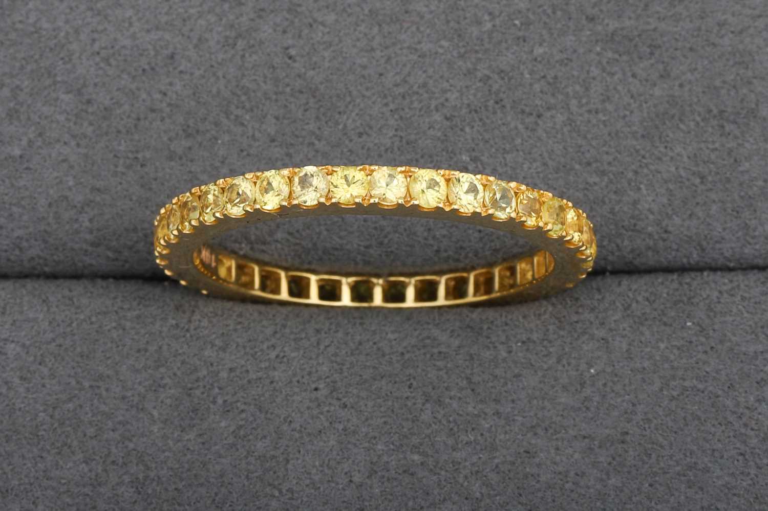 Lot 84 - A YELLOW SAPPHIRE FULL ETERNITY RING, mounted...