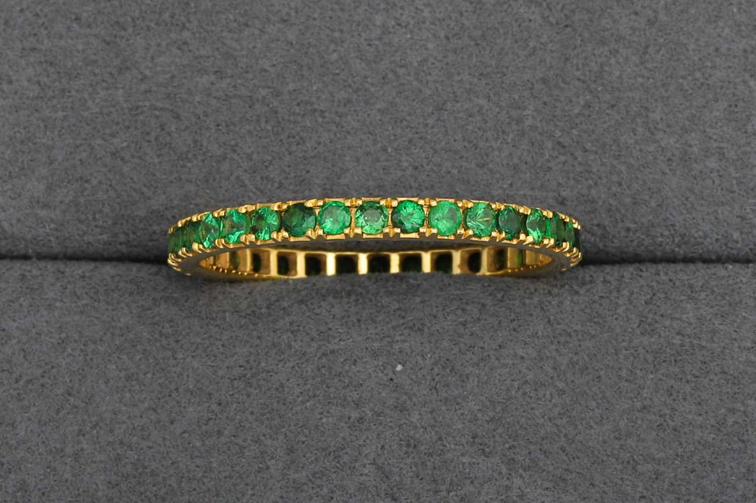 Lot 87 - A GREEN GARNET FULL ETERNITY RING, mounted in...