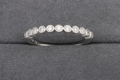 A DIAMOND SET BAND, with collet set diamonds,...