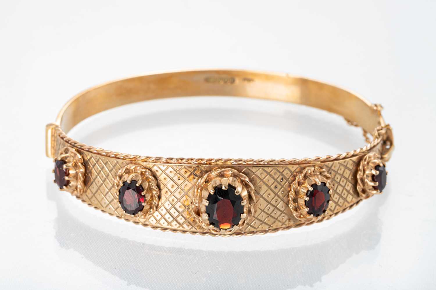 Lot 94 - A VINTAGE 9CT GOLD GARNET SET HINGED BANGLE,...