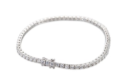 Lot 229 - A DIAMOND LINE BRACELET, the brilliant cut...