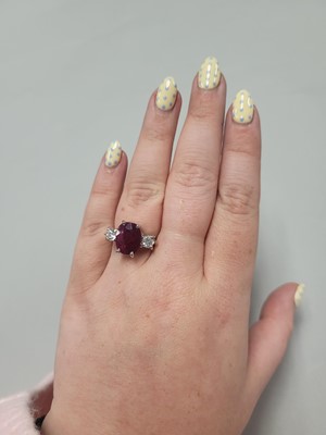 Lot 111 - A RUBY AND DIAMOND THREE STONE RING, the oval...