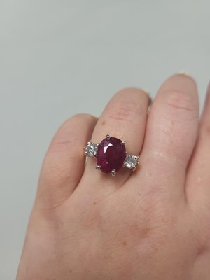 Lot 111 - A RUBY AND DIAMOND THREE STONE RING, the oval...