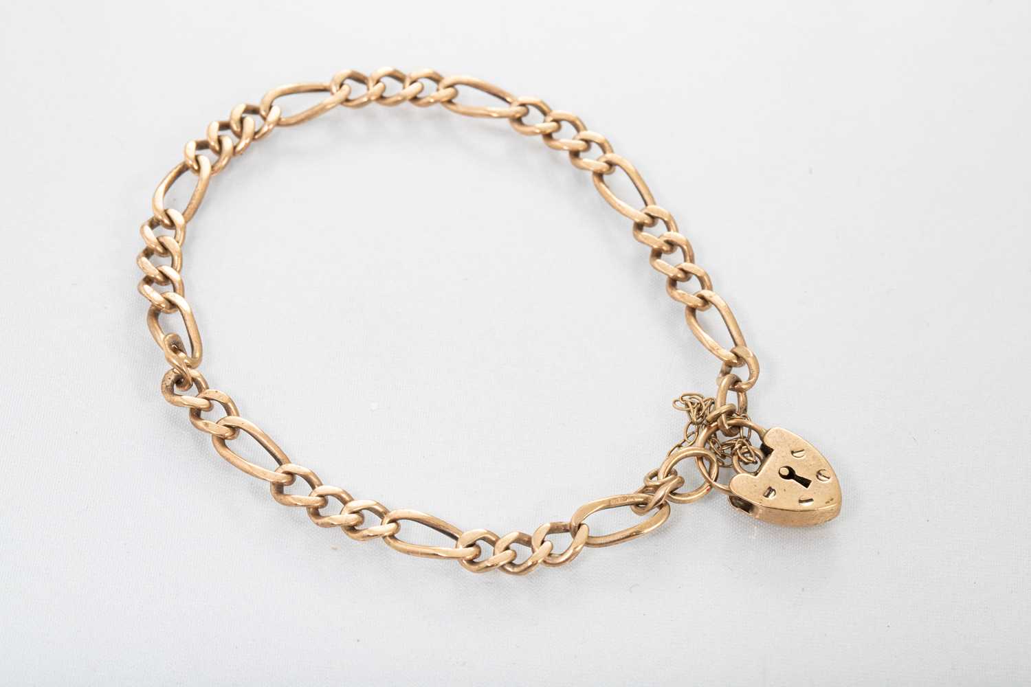 Lot 192 - A 9CT GOLD FIGARO LINK BRACELET, with padlock,...