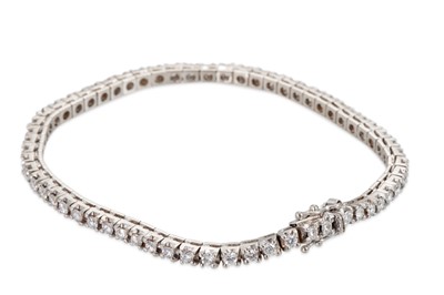 Lot 308 - A DIAMOND LINE BRACELET, set with brilliant...
