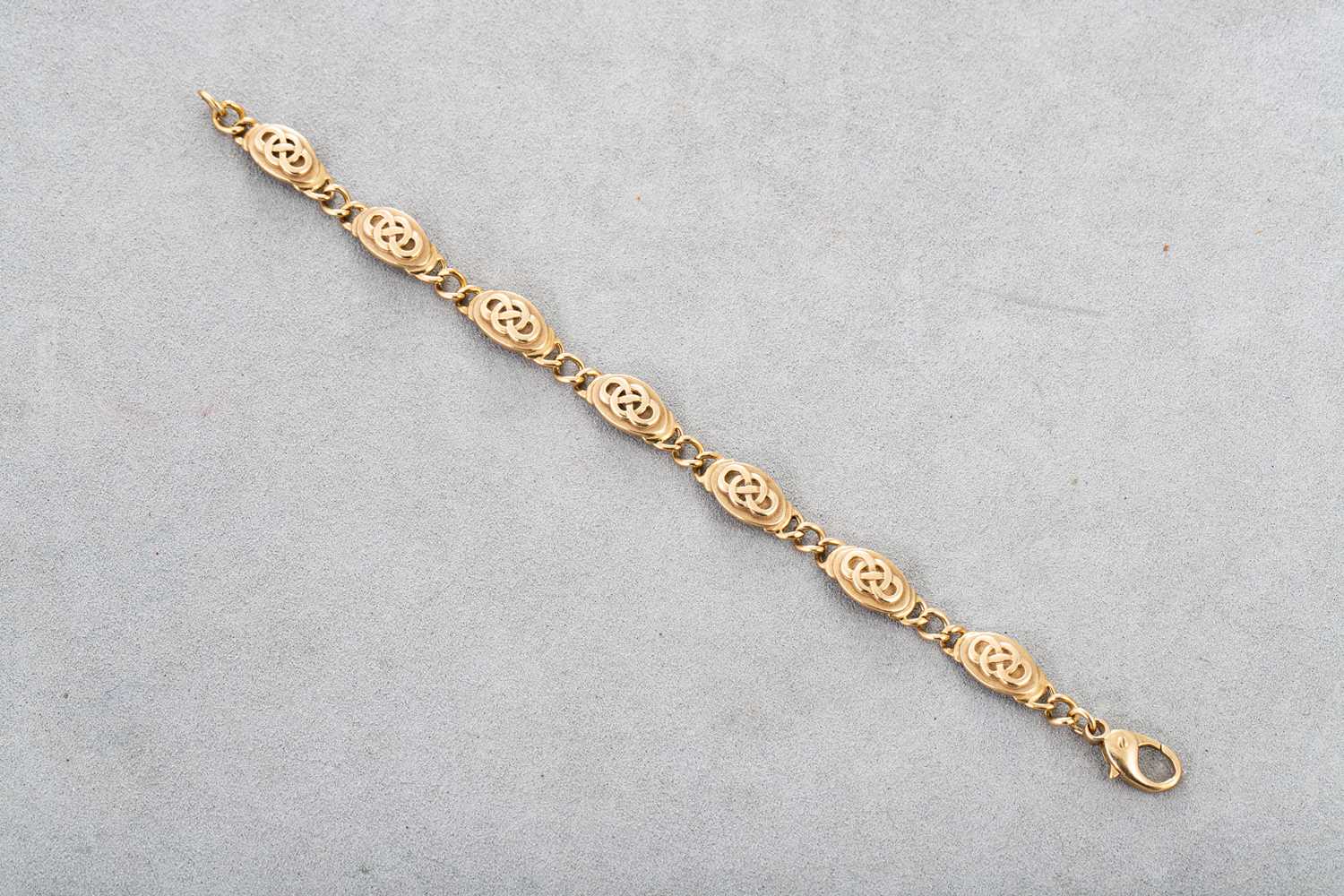 Lot 86 - A 9CT GOLD BRACELET, Celtic decoration, 20 g.