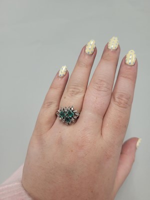 Lot 179 - AN EMERALD AND DIAMOND CLUSTER RING, set with...