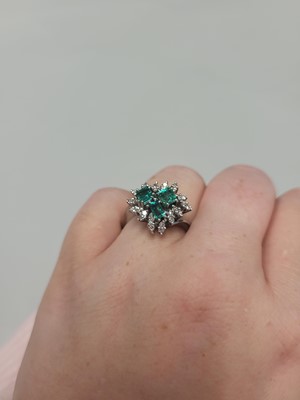 Lot 179 - AN EMERALD AND DIAMOND CLUSTER RING, set with...