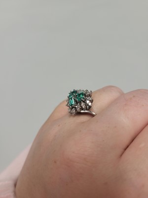 Lot 179 - AN EMERALD AND DIAMOND CLUSTER RING, set with...
