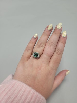 Lot 180 - AN EMERALD AND DIAMOND CLUSTER RING, the trap...