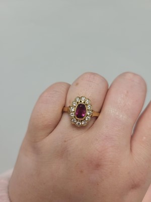 Lot 130 - A RUBY AND DIAMOND CLUSTER RING, the oval ruby...