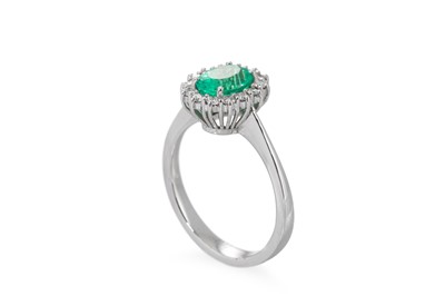 Lot 133 - AN EMERALD AND DIAMOND CLUSTER RING, the oval...