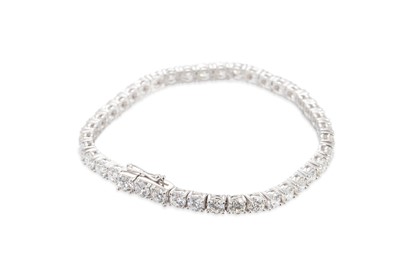 Lot 297 - A DIAMOND LINE BRACELET, the brilliant cut...