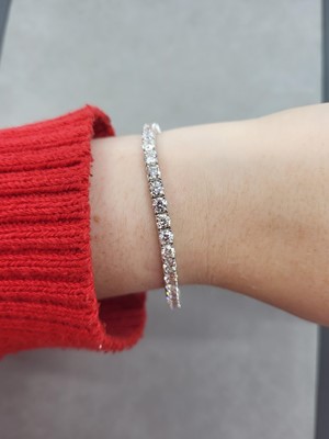 Lot 297 - A DIAMOND LINE BRACELET, the brilliant cut...