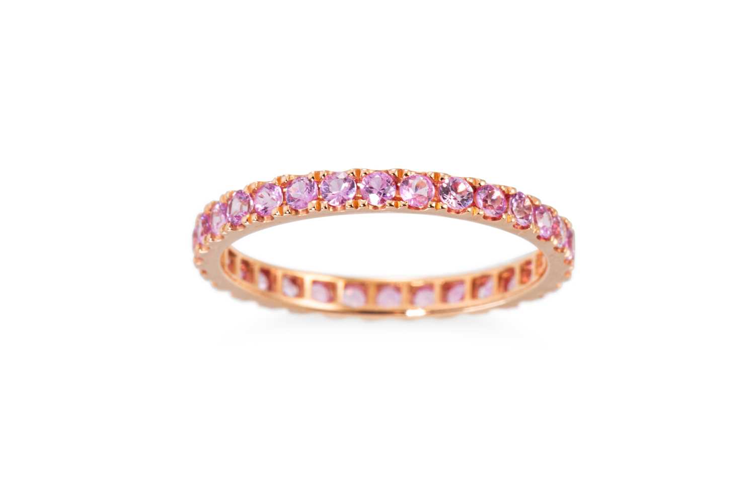 Lot 38 - A PINK SAPPHIRE ETERNITY RING, set with...