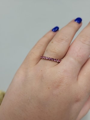 Lot 38 - A PINK SAPPHIRE ETERNITY RING, set with...