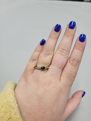 Lot 61 - AN EMERALD AND DIAMOND SET BAND RING, the oval...