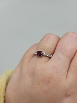 Lot 62 - A RUBY AND DIAMOND SET BAND RING, the oval...