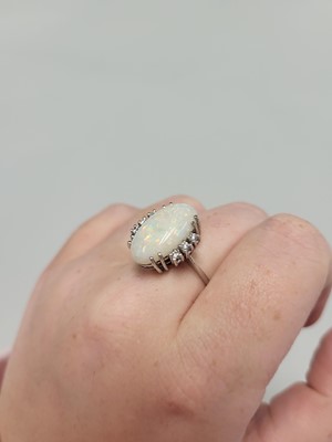 Lot 122 - AN OPAL AND DIAMOND RING, the oval opal to a...