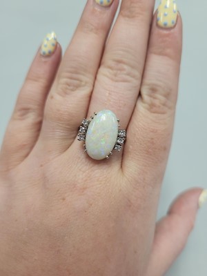 Lot 122 - AN OPAL AND DIAMOND RING, the oval opal to a...