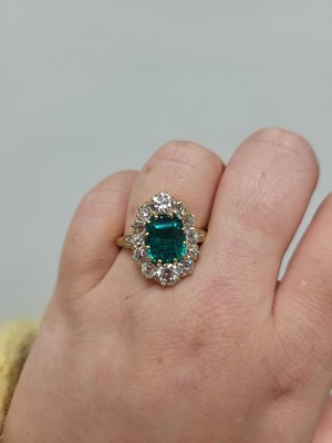 Lot 228 - A VINTAGE DIAMOND AND EMERALD CLUSTER RING,...
