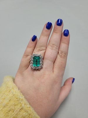 Lot 56 - AN EMERALD AND DIAMOND CLUSTER RING, the...