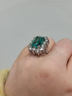 Lot 56 - AN EMERALD AND DIAMOND CLUSTER RING, the...