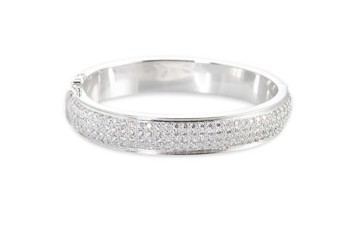 Lot 26 - A FOUR ROWED DIAMOND SET BANGLE, the round...