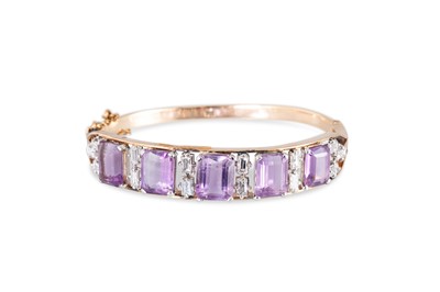 Lot 216 - AN AMETHYST AND DIAMOND SET BANGLE, the...