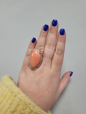 Lot 82 - A CORAL AND DIAMOND CLUSTER RING, the large...