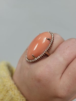 Lot 82 - A CORAL AND DIAMOND CLUSTER RING, the large...