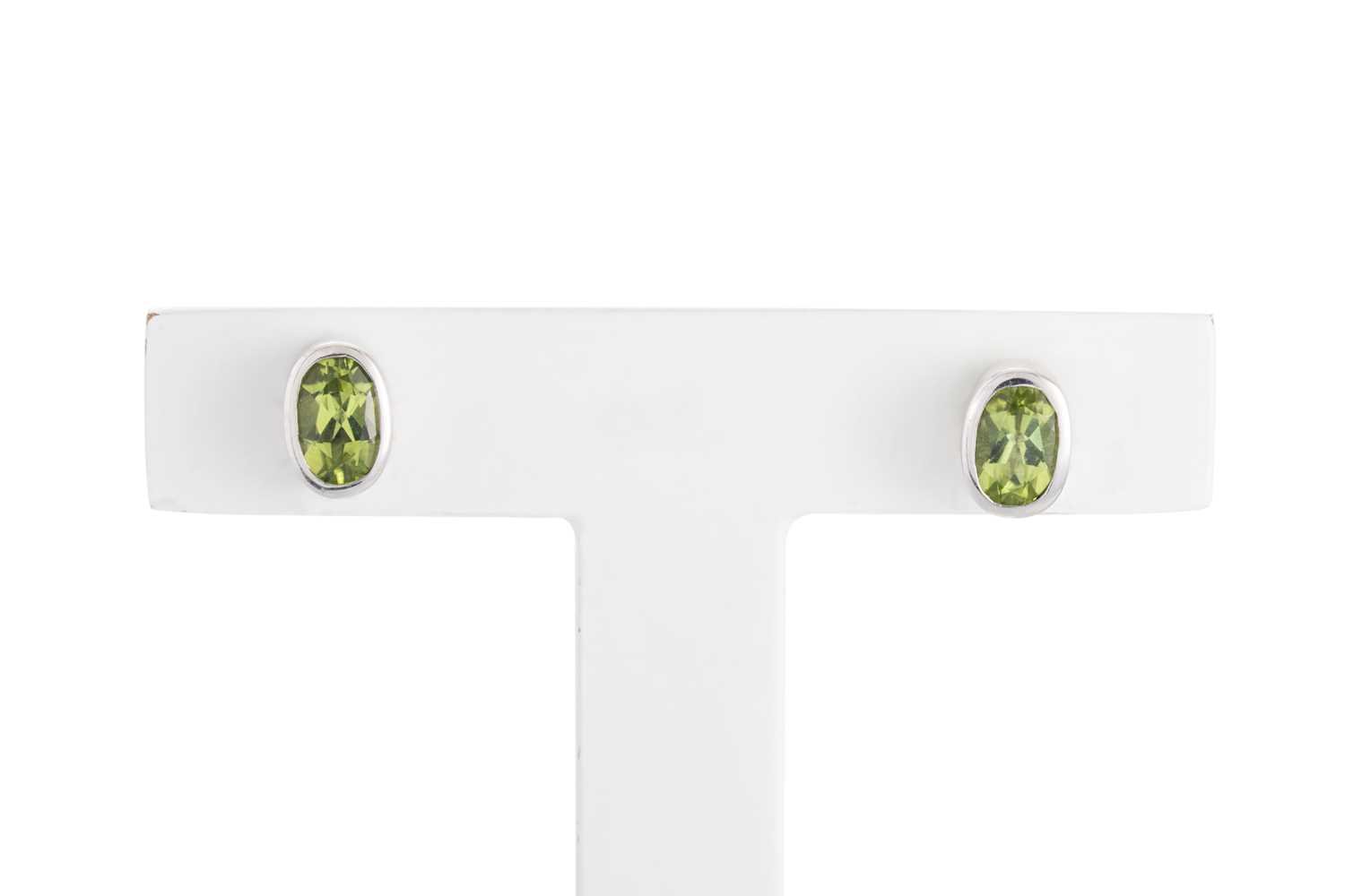 Lot 75 - A PAIR OF PERIDOT STUD EARRINGS, the oval...