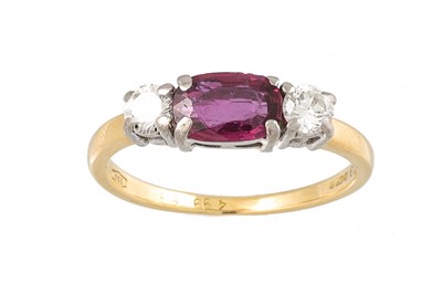 Lot 428 - A DIAMOND AND RUBY THREE STONE RING, set with...