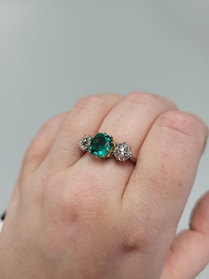 Lot 307 - An EMERALD AND DIAMOND THREE STONE RING, the...