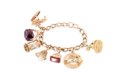 Lot 239 - A 9CT GOLD VINTAGE CHARM BRACELET, suspending...