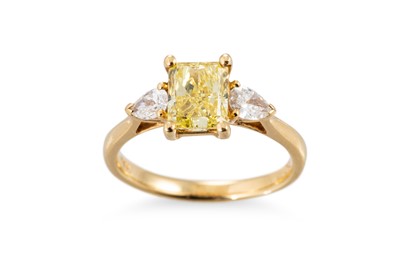 Lot 314 - A FANCY VIVID YELLOW DIAMOND RING, the central...