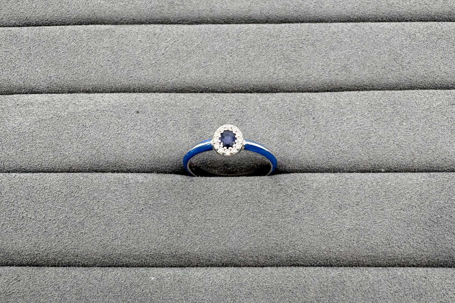 AN ENAMEL, SAPPHIRE AND DIAMOND RING, the oval...