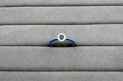 AN ENAMEL, SAPPHIRE AND DIAMOND RING, the oval...