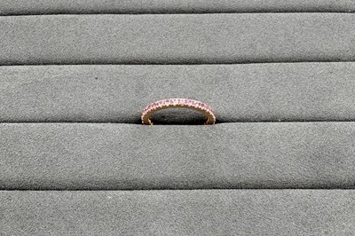 A PINK SAPPHIRE FULL ETERNITY RING, the round...