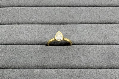 A DIAMOND SOLITAIRE RING, the bezel set pear...