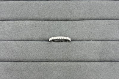 A DIAMOND HALF ETERNITY RING, the round...