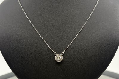 A DIAMOND CLUSTER PENDANT, the principal round...