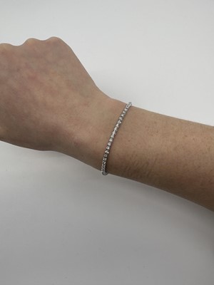 A DIAMOND LINE BRACELET, the round brilliant...
