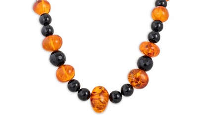 Lot 98 - A VINTAGE STRING OF AMBER & POLISHED JET BEADS,...