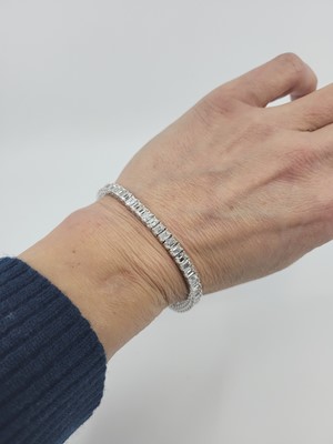 Lot 221 - AN IMPORTANT EMERALD CUT DIAMOND LINE BRACELET,...