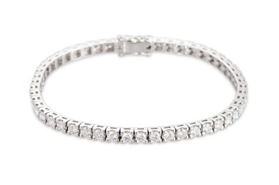 Lot 223 - A DIAMOND LINE BRACELET, the brilliant cut...
