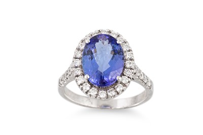 Lot 242 - A TANZANITE AND DIAMOND CLUSTER RING, the oval...